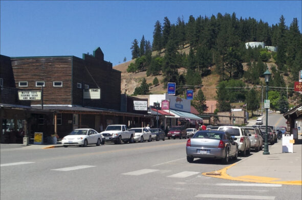 Photo of Clark Ave in Republic, WA. Car-lined main street with mountain in background.